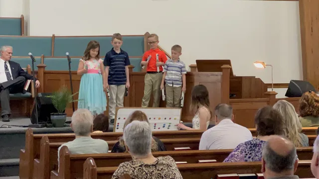 Children playing handbells at the front of the sanctuary